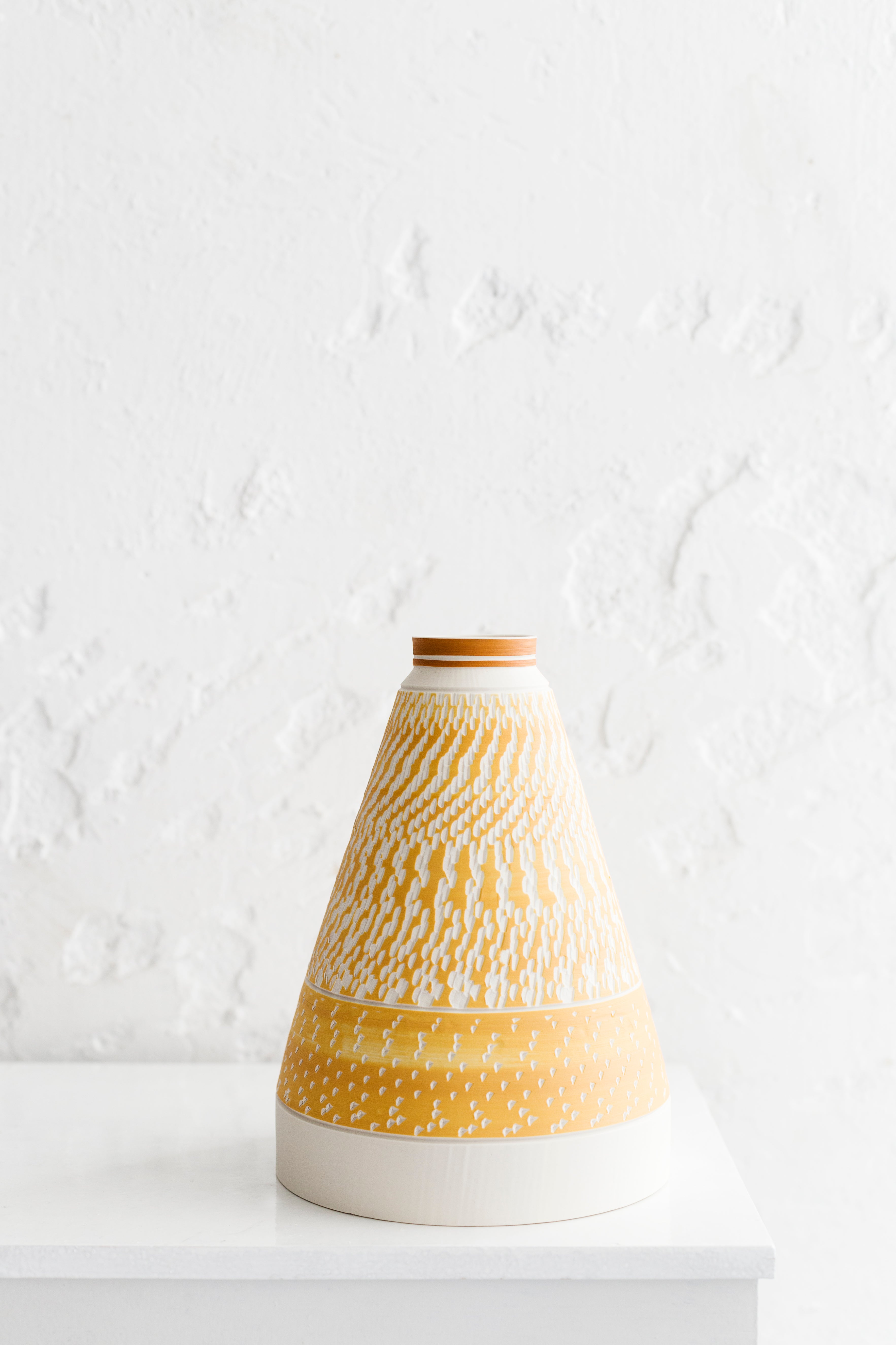 Tall white pyramid vase with chattering decoration